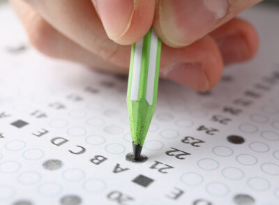 Student fills answers test sheet, close up Student fills answers test sheet, close up
